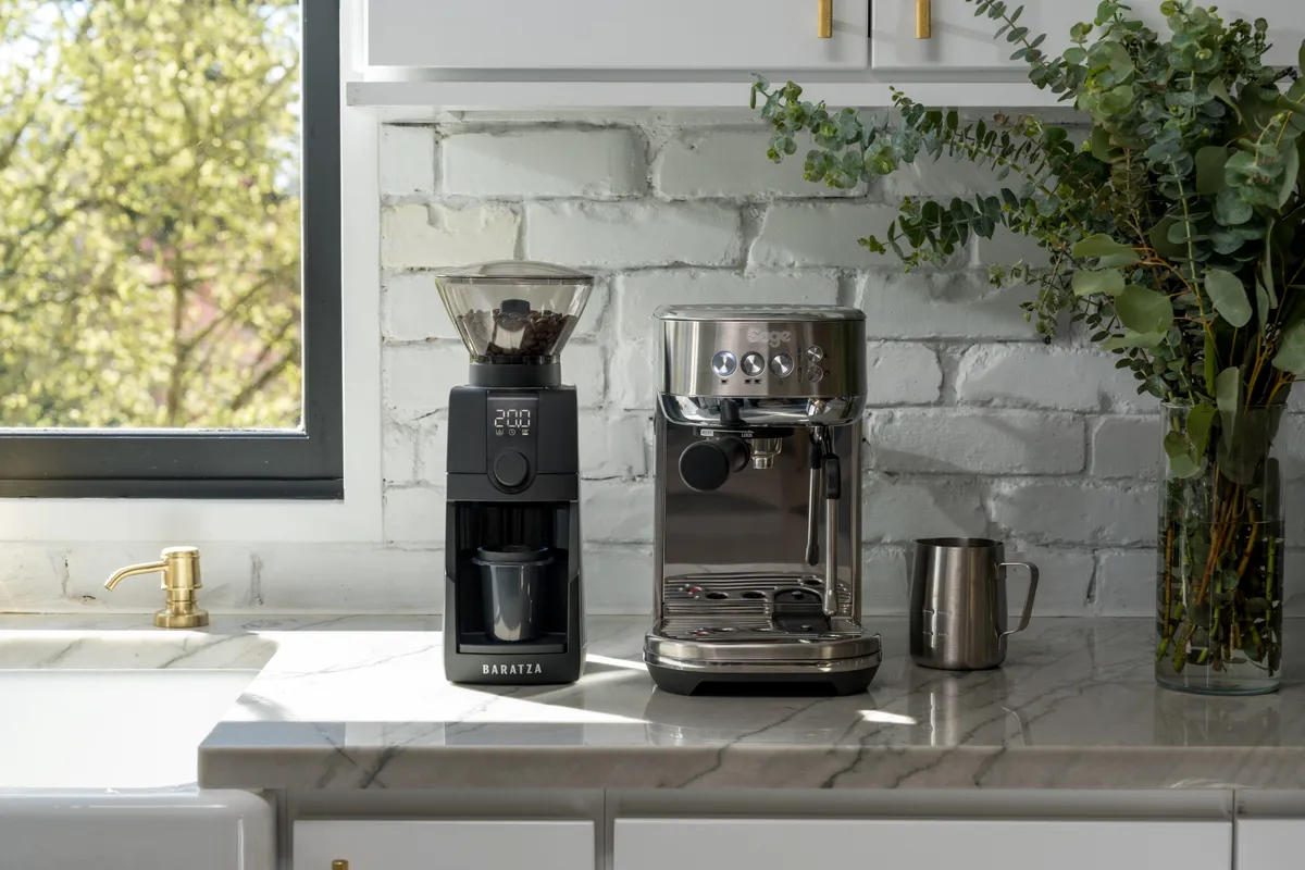 Kettle pouring water into a white hario v60 to brew pour over coffee surrounded by flowers.