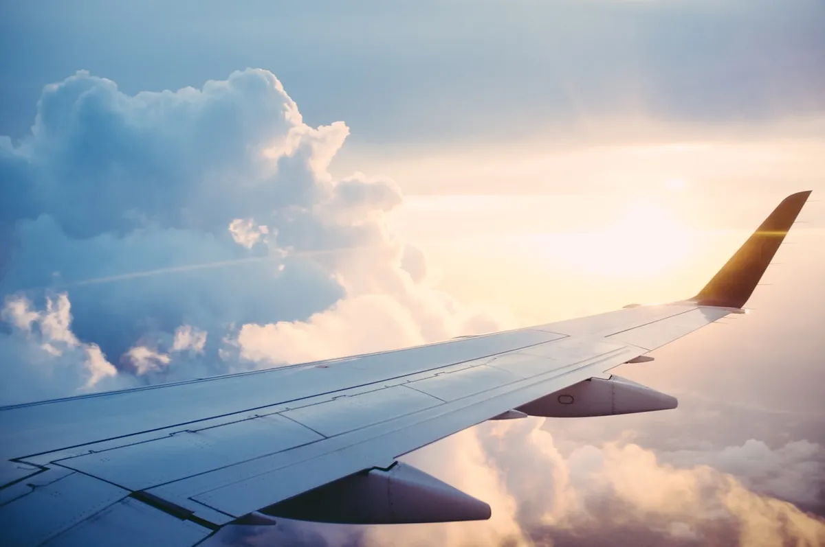 Airplane wing above clouds during travel