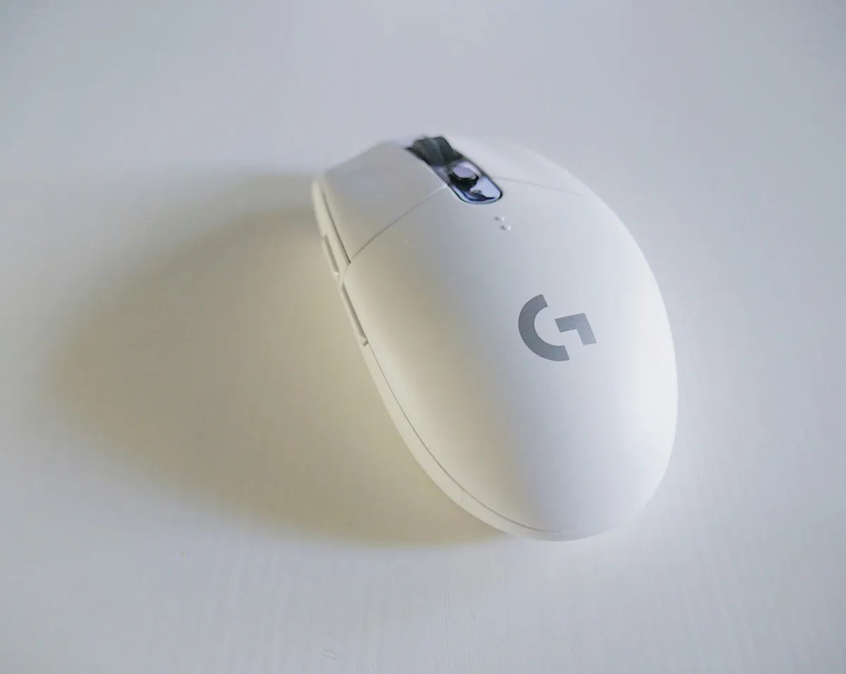 Wireless productivity mouse beside a keyboard and laptop