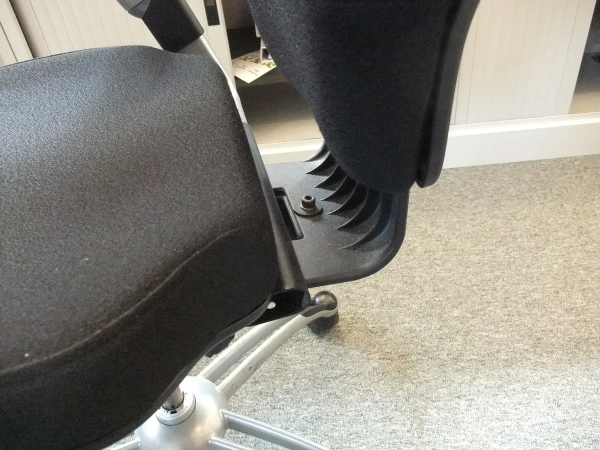 An office chair viewed from the side showing backrest and armrests