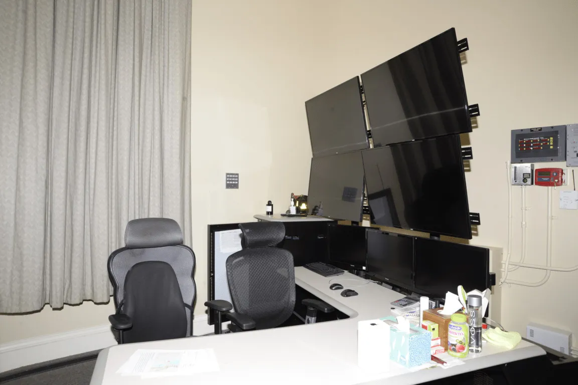A workstation with two ergonomic chairs and multiple monitors