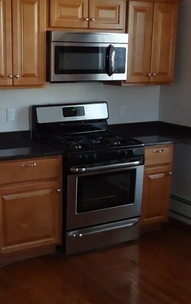 A microwave oven installed above a conventional stove and oven