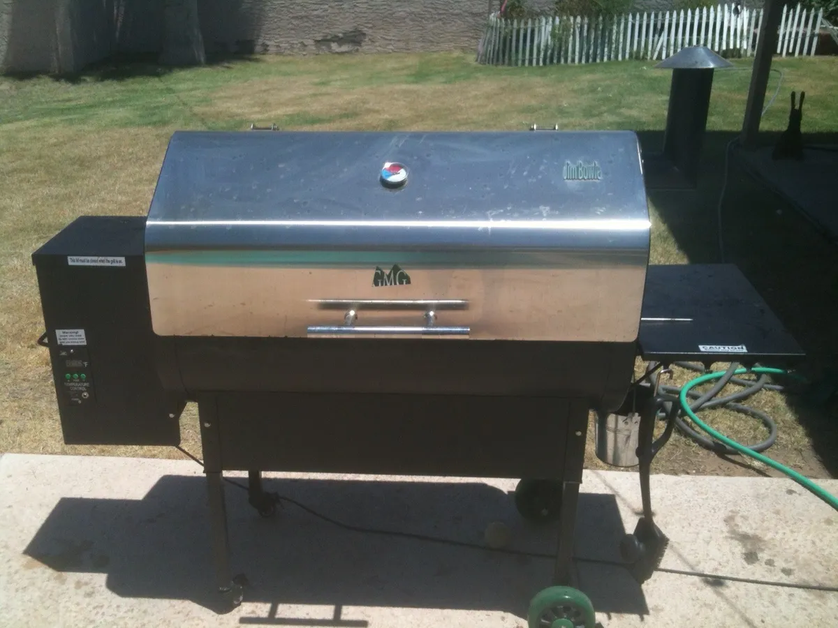 A pellet grill with a hopper on the side