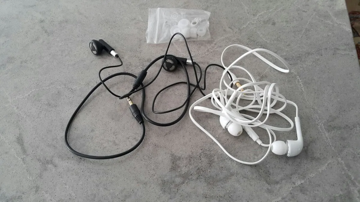 Close-up comparison of two in-ear monitor style earpieces with silicone tips
