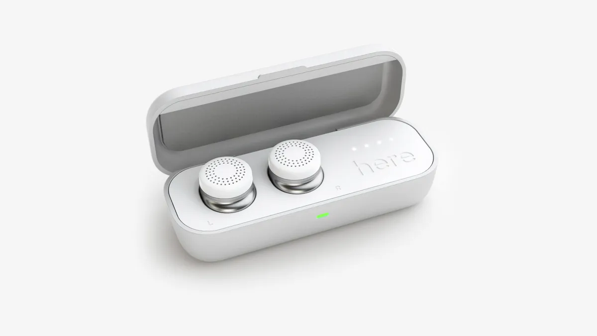 Wireless earbuds resting in an open white charging case