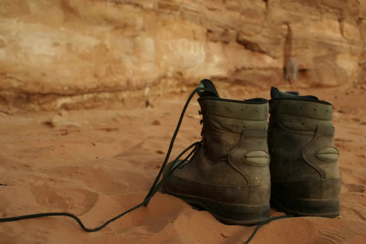 Hiking boots standing on sandy ground