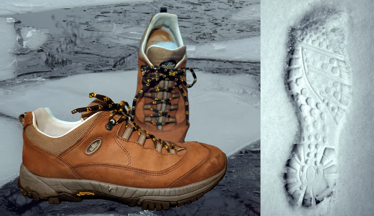 Hiking boots leaving a footprint in fresh snow