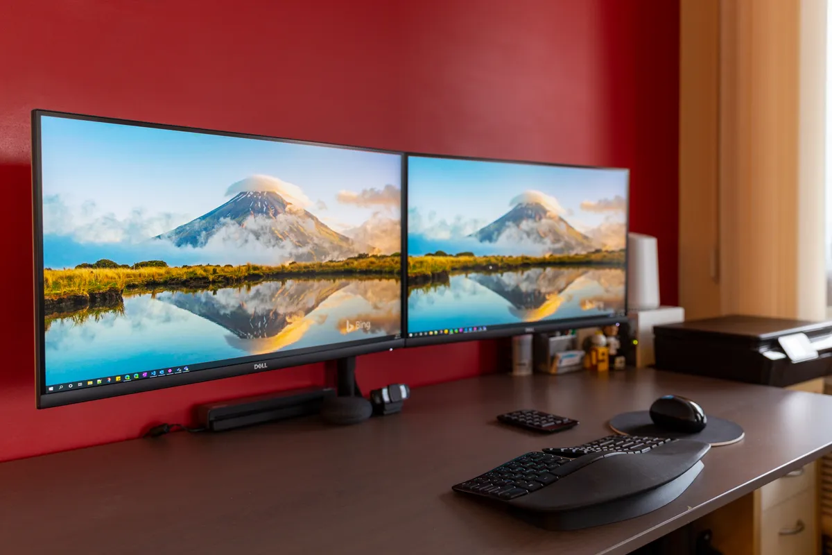 A home office desk with multiple monitors and a laptop