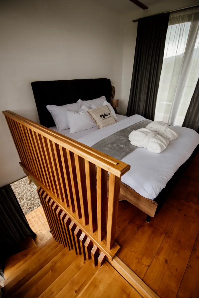 A bed dressed with pillows and a throw blanket