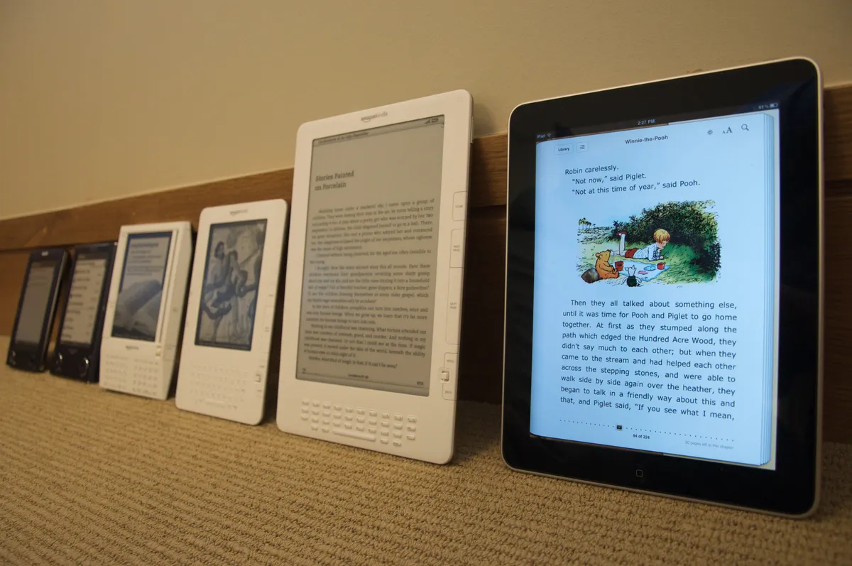 Several generations of e-reader devices side by side