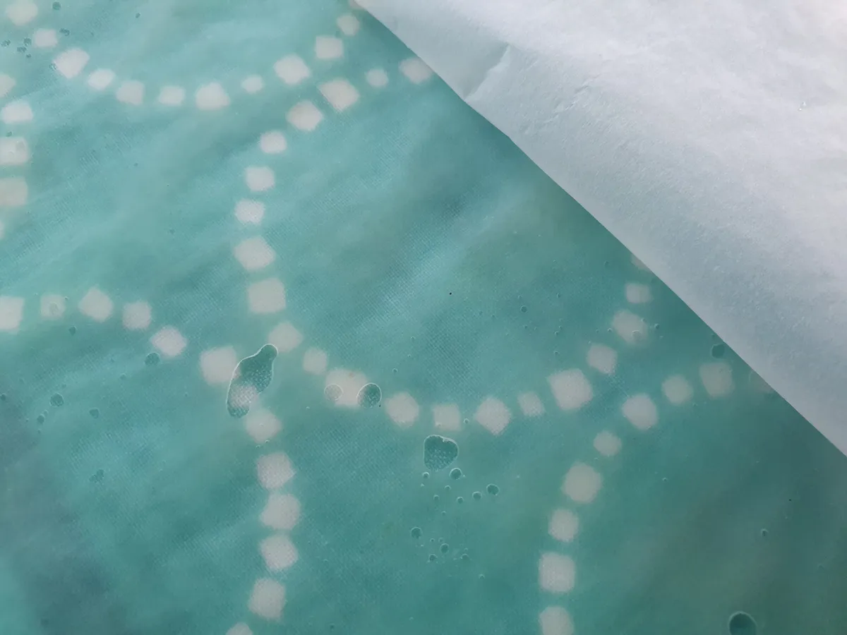 Cotton fabric being coated with beeswax to make food wrap