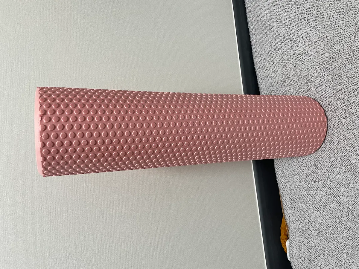 A textured foam roller on the floor