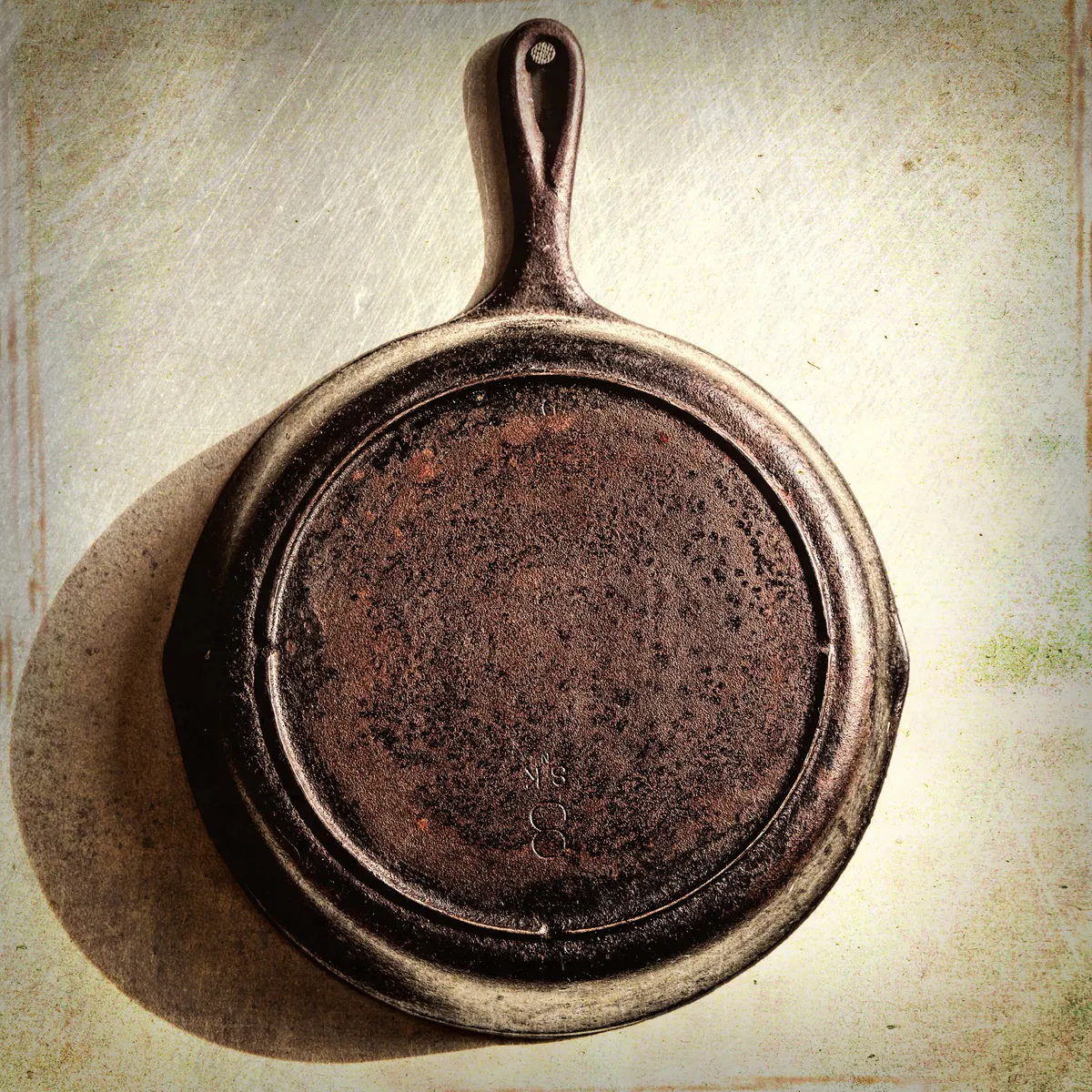 A frying pan with food being lifted out