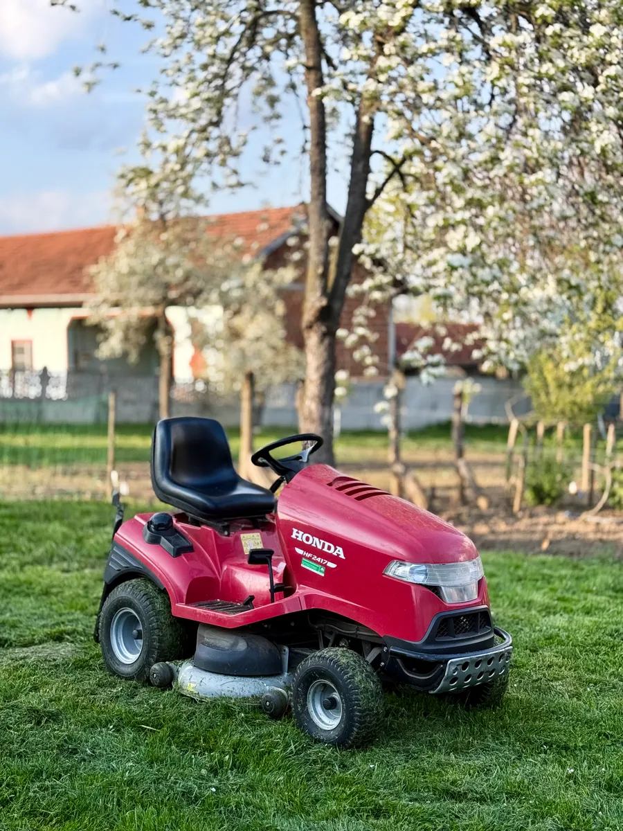 A riding mower cutting grass in a garden