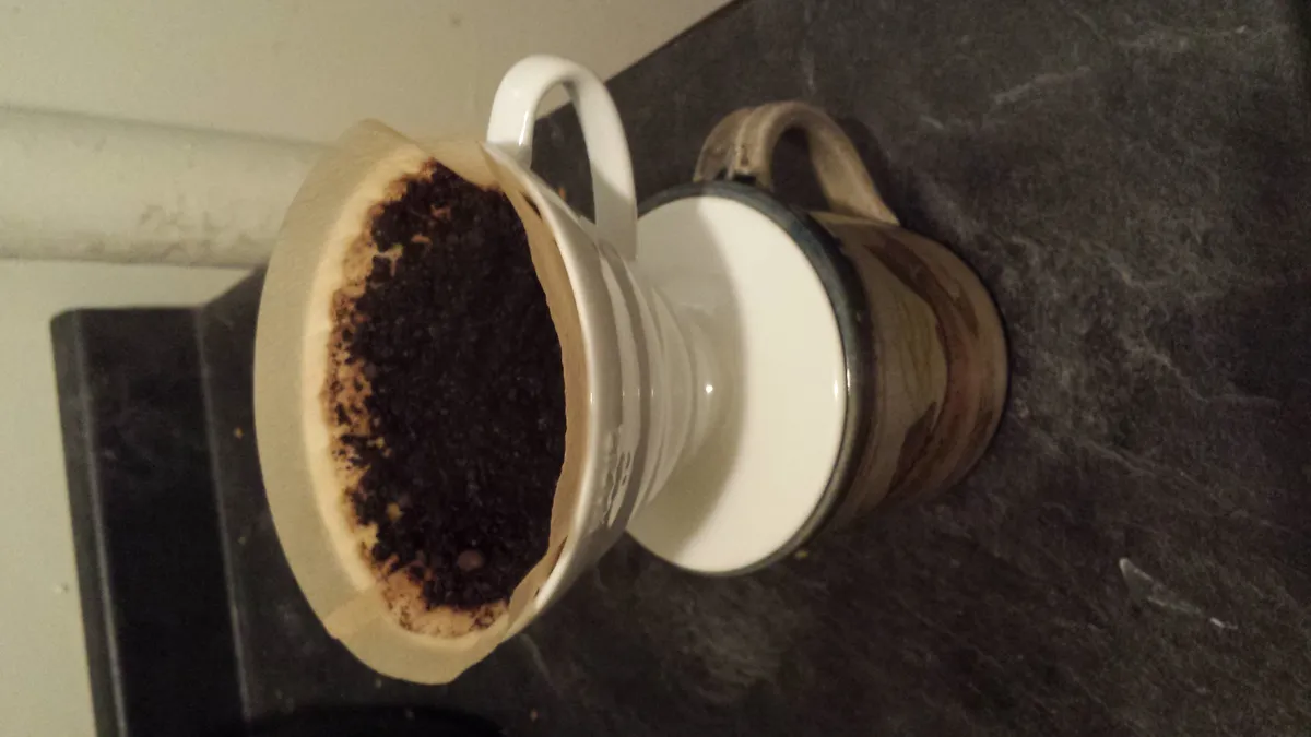Hot water being poured over a coffee bed in a conical pour-over dripper