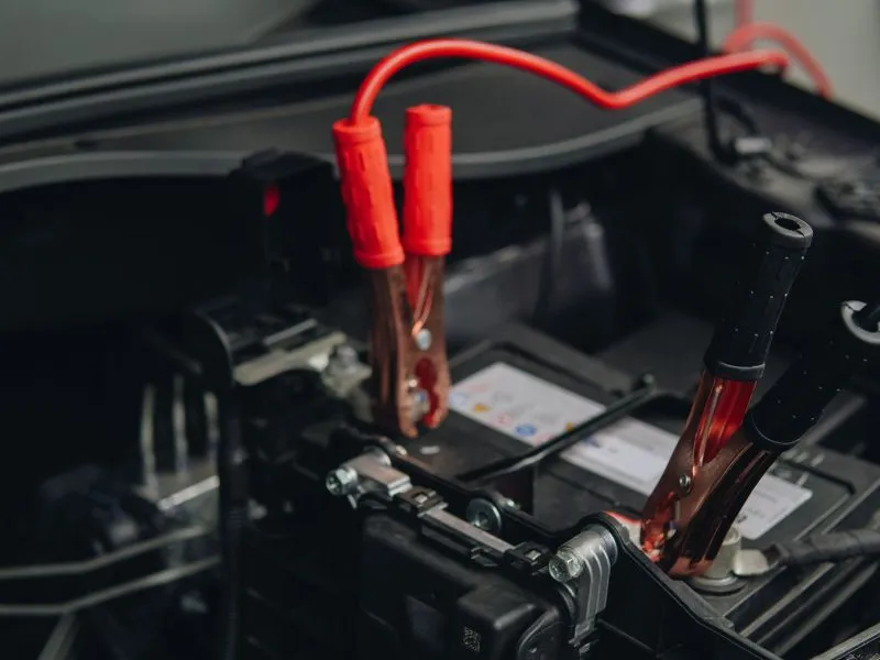 A vehicle battery being boosted at the roadside