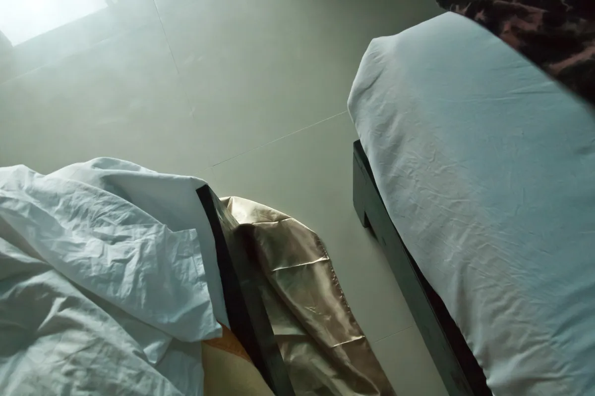 A neatly made hotel bed with layered bedding