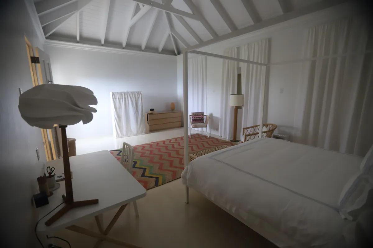 A minimalist bedroom with a wooden bed frame and natural light