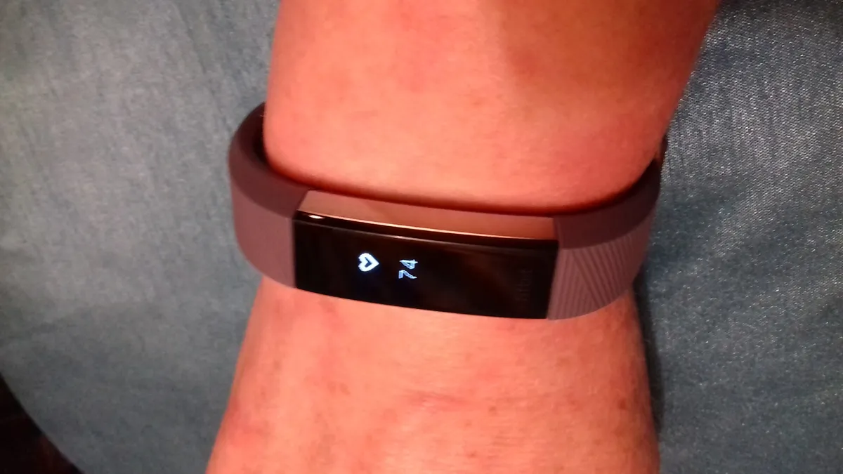 A slim fitness tracker band with a small display