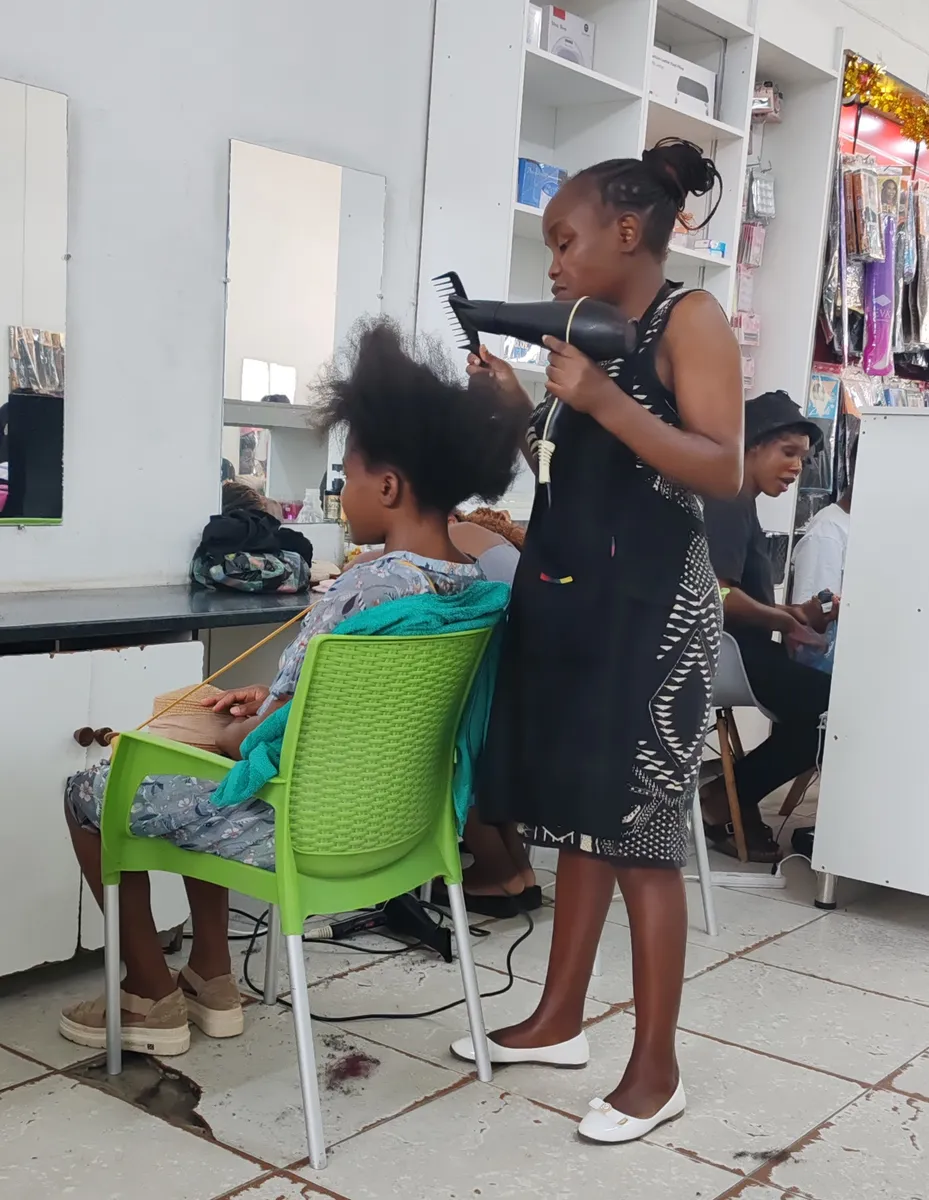A stylist blow-drying a client's hair