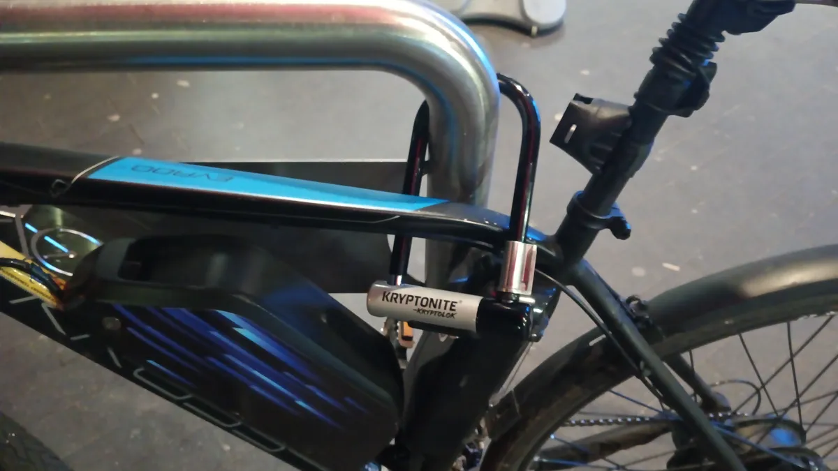 Bicycle secured to a rack with a U-lock through the frame and rear wheel
