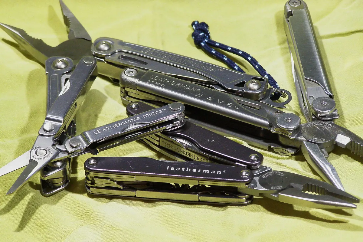 Leatherman multi-tool displayed with its tools extended on a wooden surface