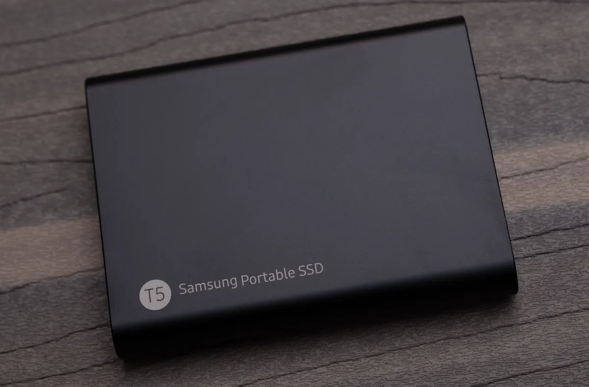 Samsung T5 portable SSD held in a hand for scale