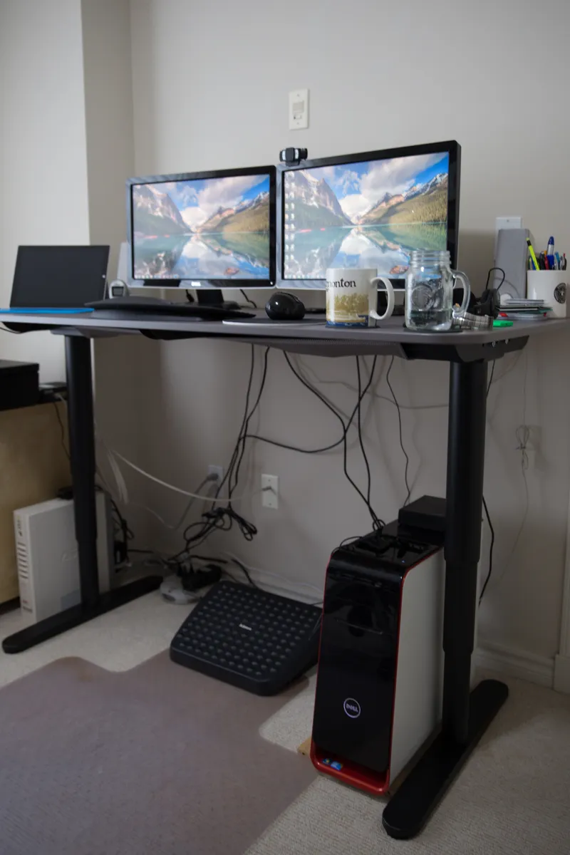 Sit-stand desk raised to standing height with monitor and keyboard