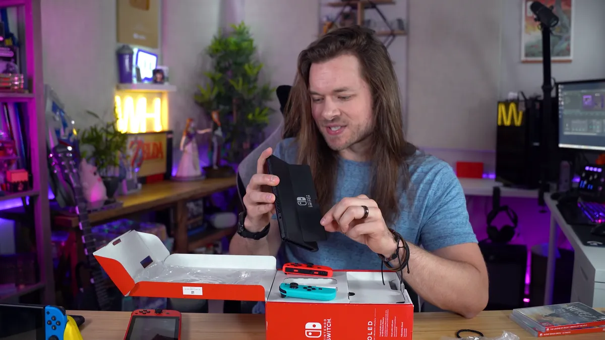 Nintendo Switch OLED console in handheld mode showing the wider kickstand