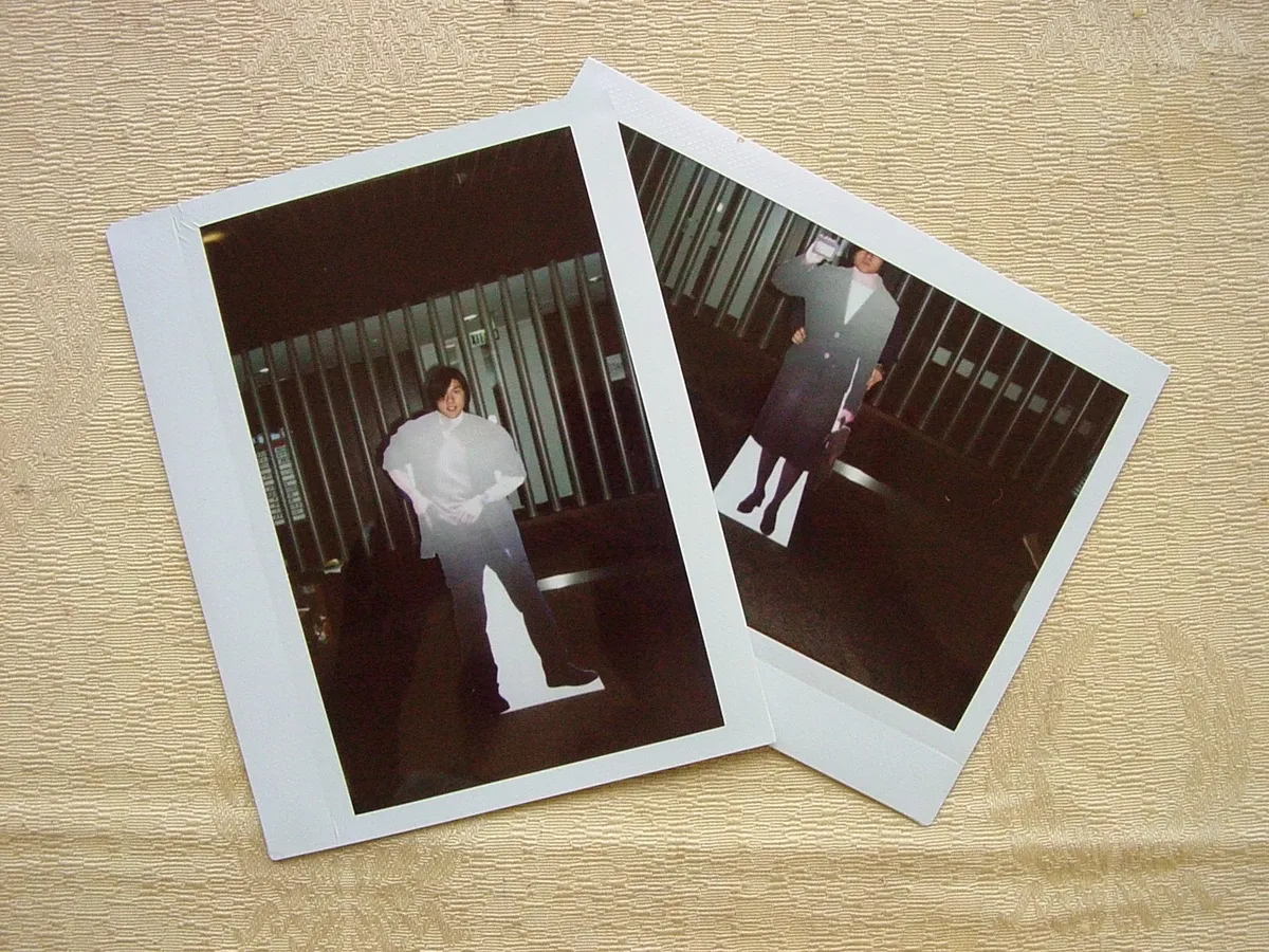 Collection of developed instant film photographs spread out showing varied exposures and subjects