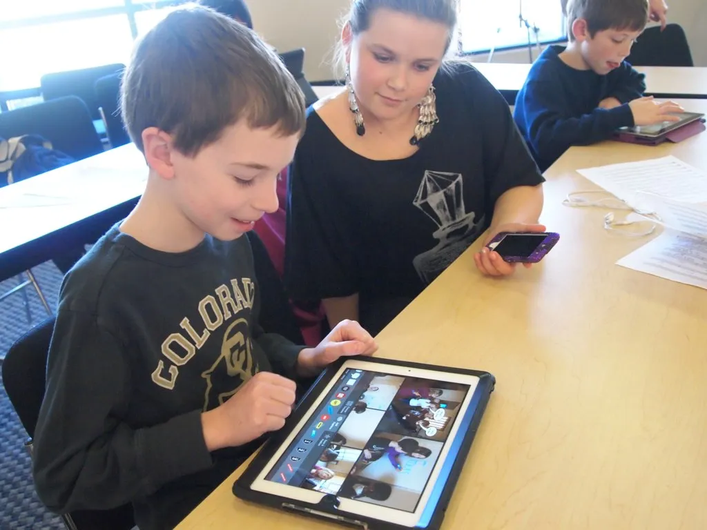 Young students engaging with an iPad in a classroom environment during a learning activity