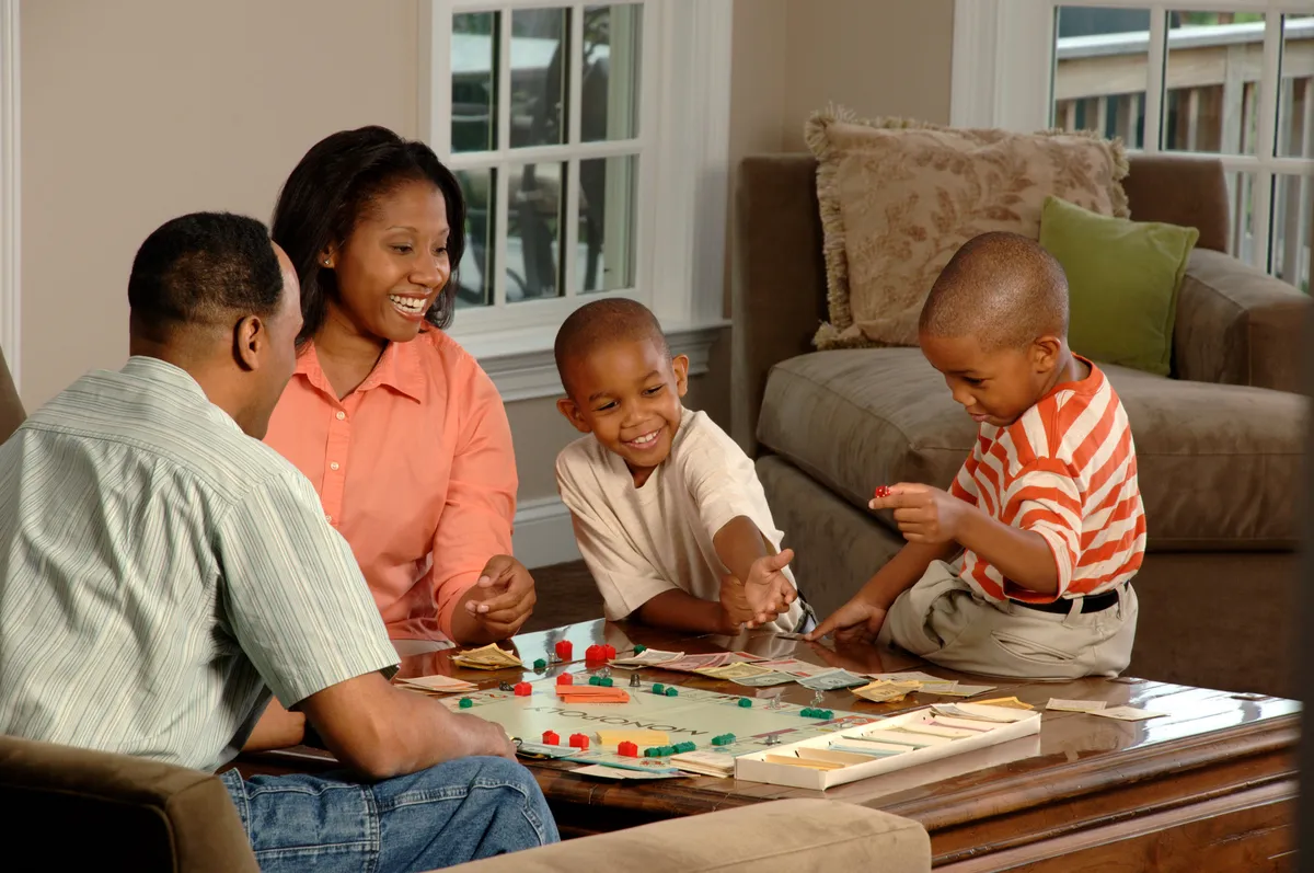 Family gathered around a table engaged in a hands-on game activity together
