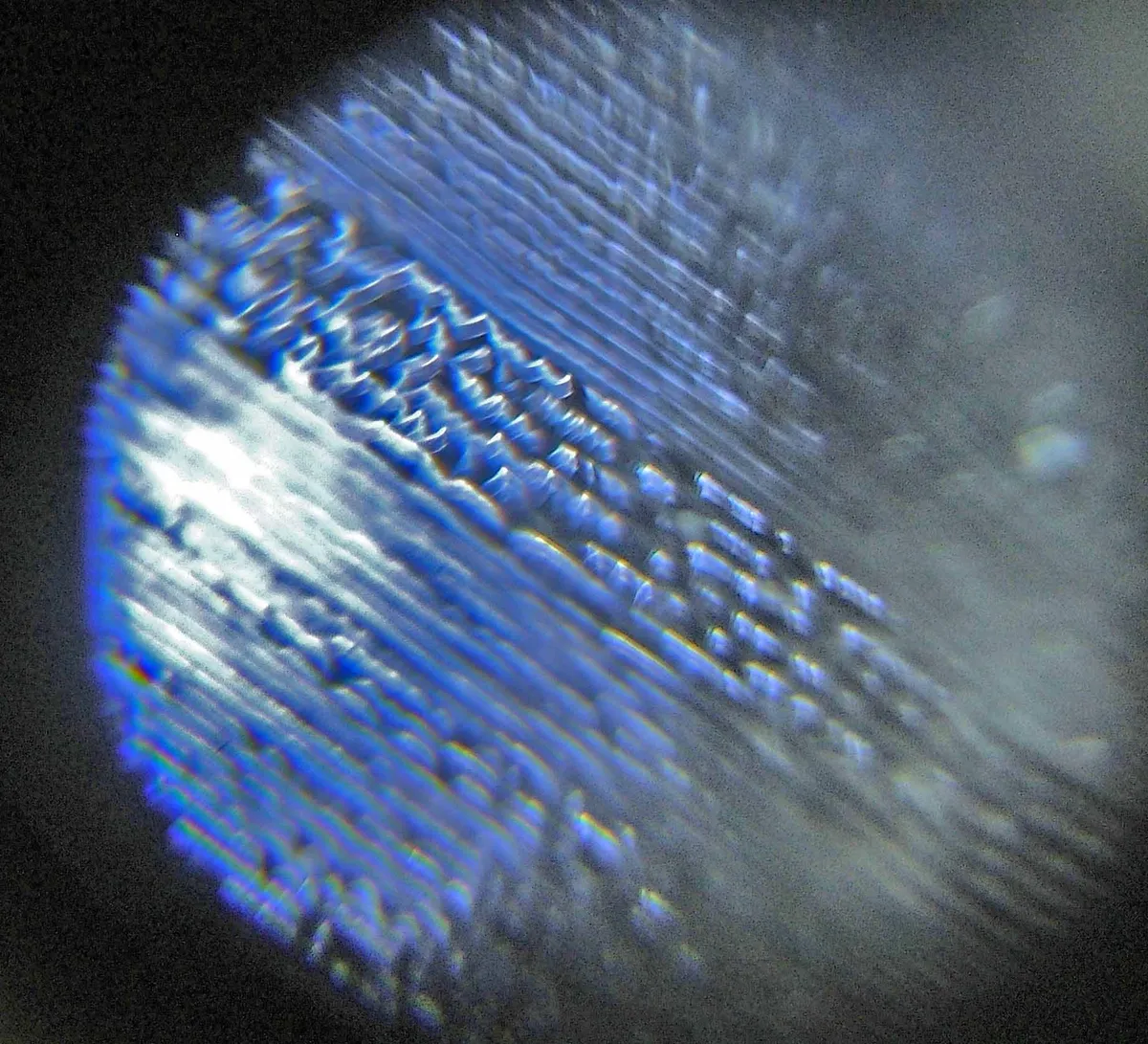 Close-up of an LP record groove showing the modulated walls the stylus tracks