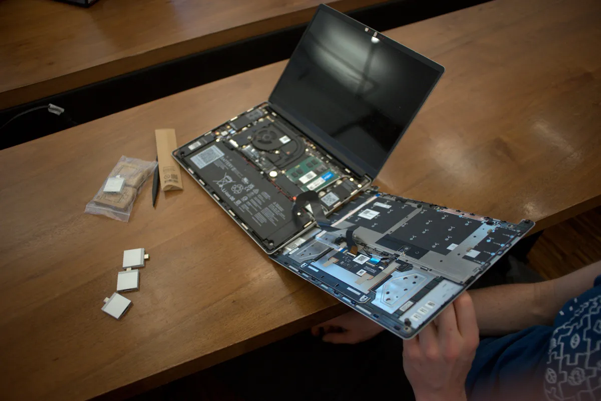 Interior view of a Framework laptop with several Expansion Cards inserted and visible internals