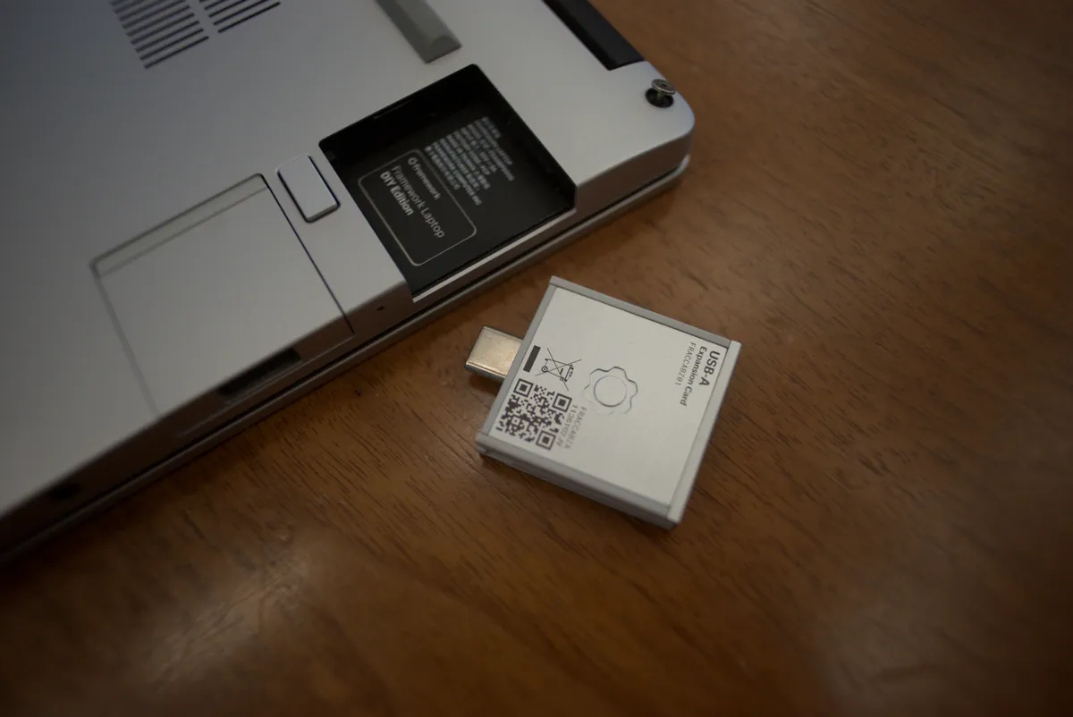 Close-up of a Framework laptop Expansion Card and its empty slot on the chassis edge