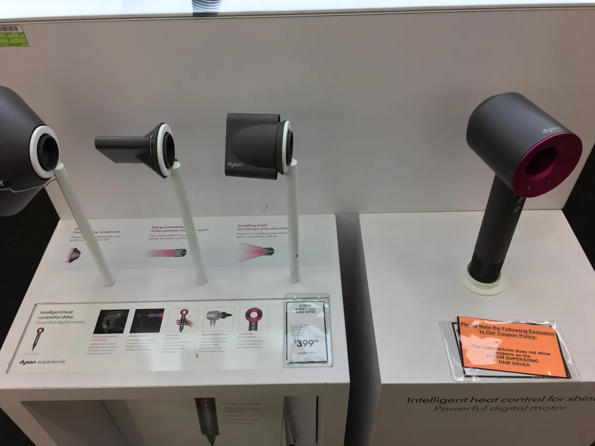 Side profile of a Dyson hair care tool showing its compact head design and cord, representative of the brand's styling tool family