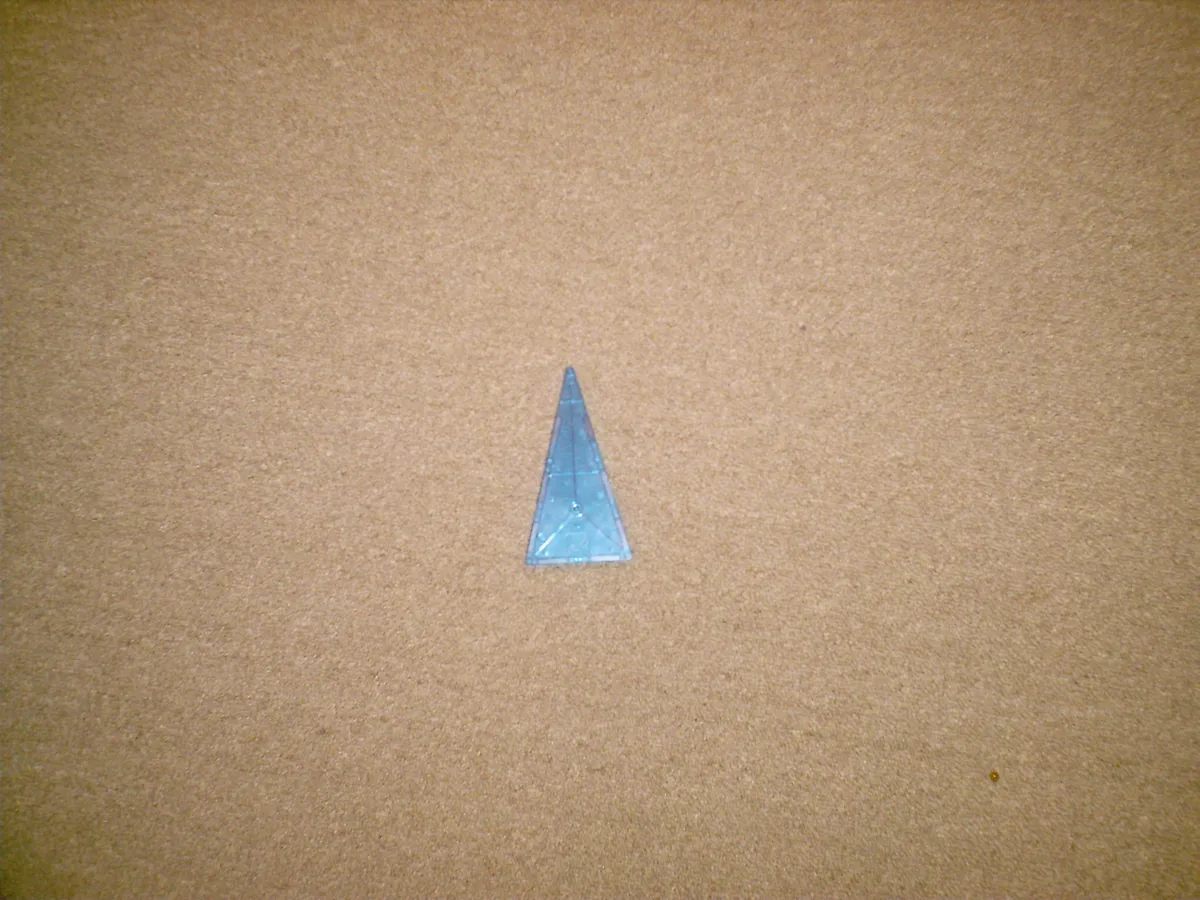 Close-up of a single translucent blue triangular Magna-Tile showing the magnet edge construction