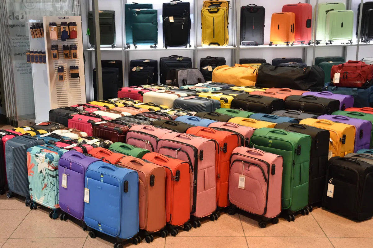 Hardshell trolley suitcases with spinner wheels lined up, illustrating the wheel and shell style typical of premium carry-ons