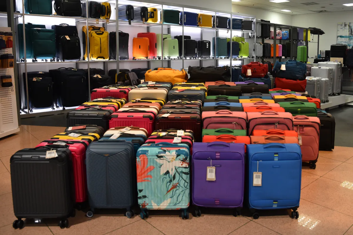 Row of hardshell trolley suitcases showing shell texture and corner construction relevant to durability testing