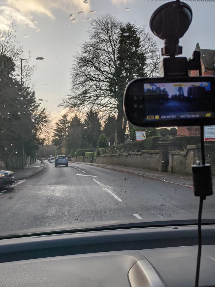 Dash camera view of a road through a car windshield while driving