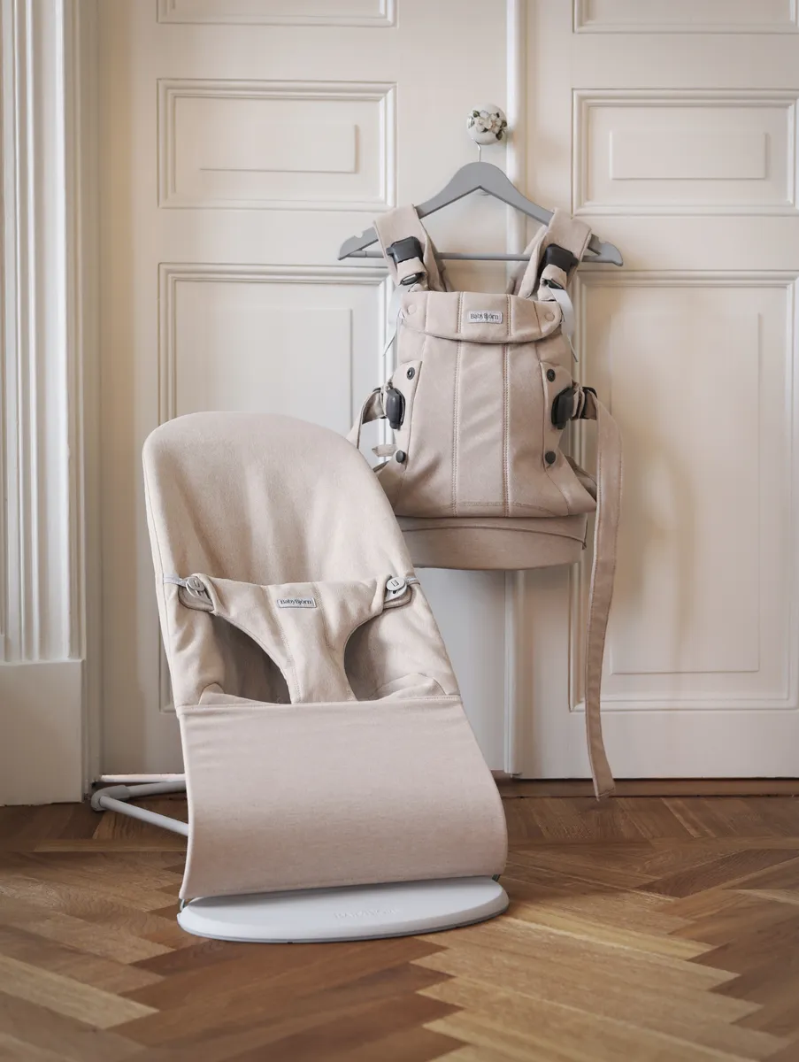BabyBjorn structured baby carrier shown alongside a baby bouncer, a common competitor to the Ergobaby Omni 360