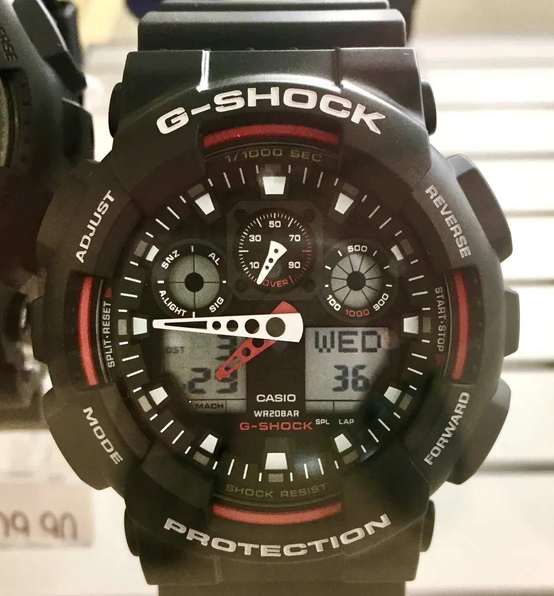 Casio G-Shock GA-100 analog-digital watch, a larger sibling design shown for case-size comparison