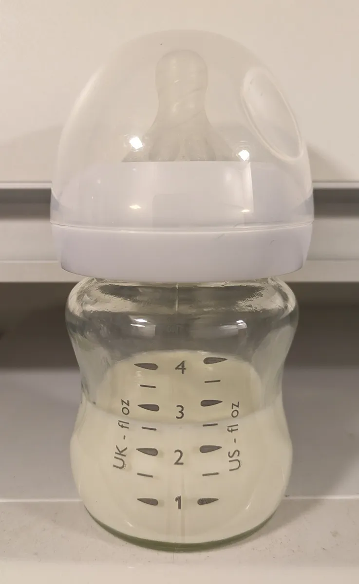 Empty baby bottle with nipple attached, the kind used to catch dispensed formula from an automatic mixer