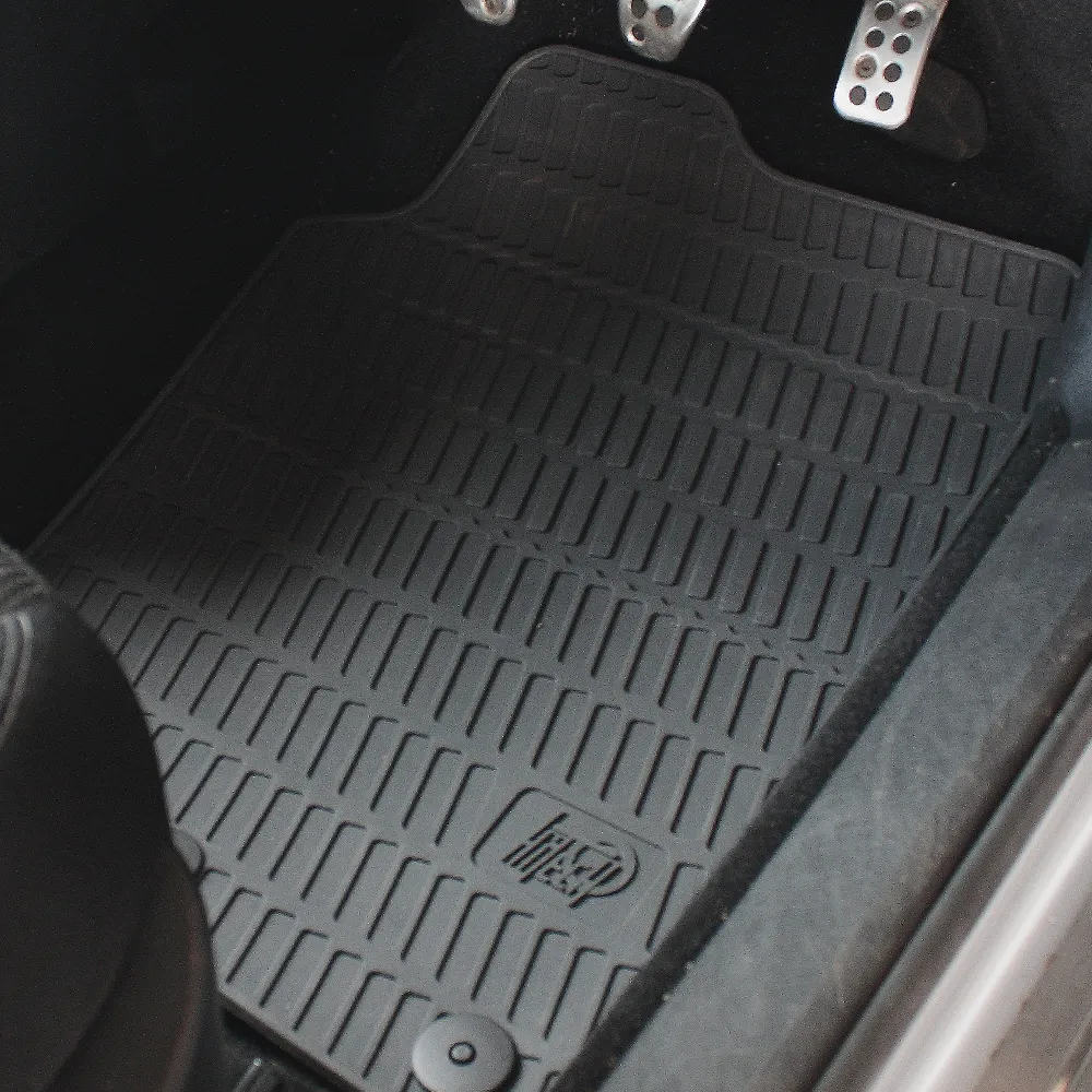 Close-up of a fitted rubber car floor mat showing the textured, grip-oriented surface pattern