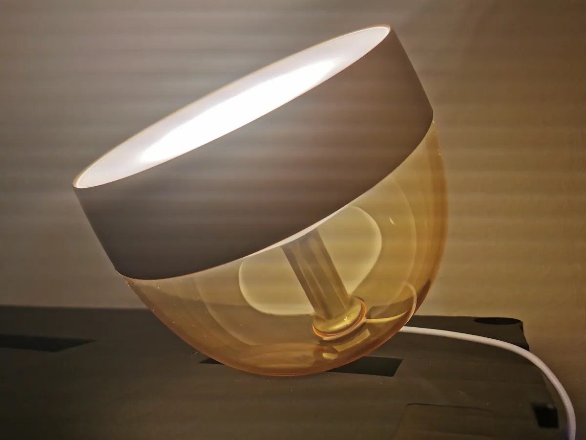 Philips Hue bulb in a gold fixture emitting warm white light