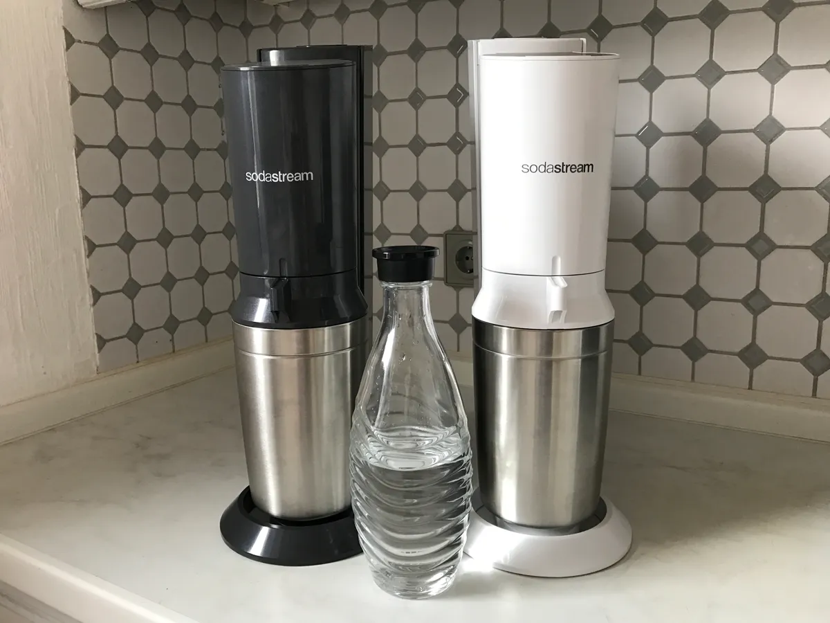 SodaStream sparkling water maker shown with a glass carafe