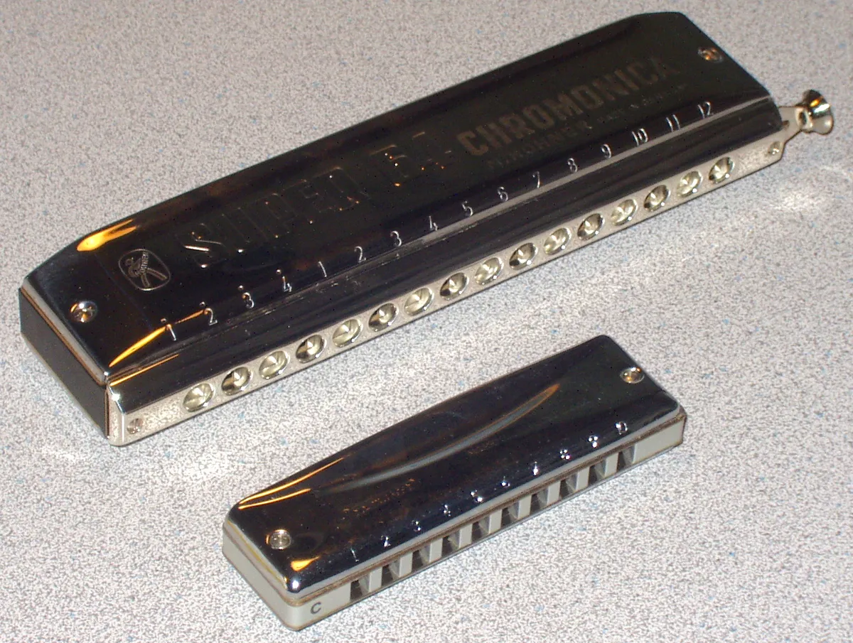 A 16-hole chromatic harmonica beside a 10-hole diatonic for comparison