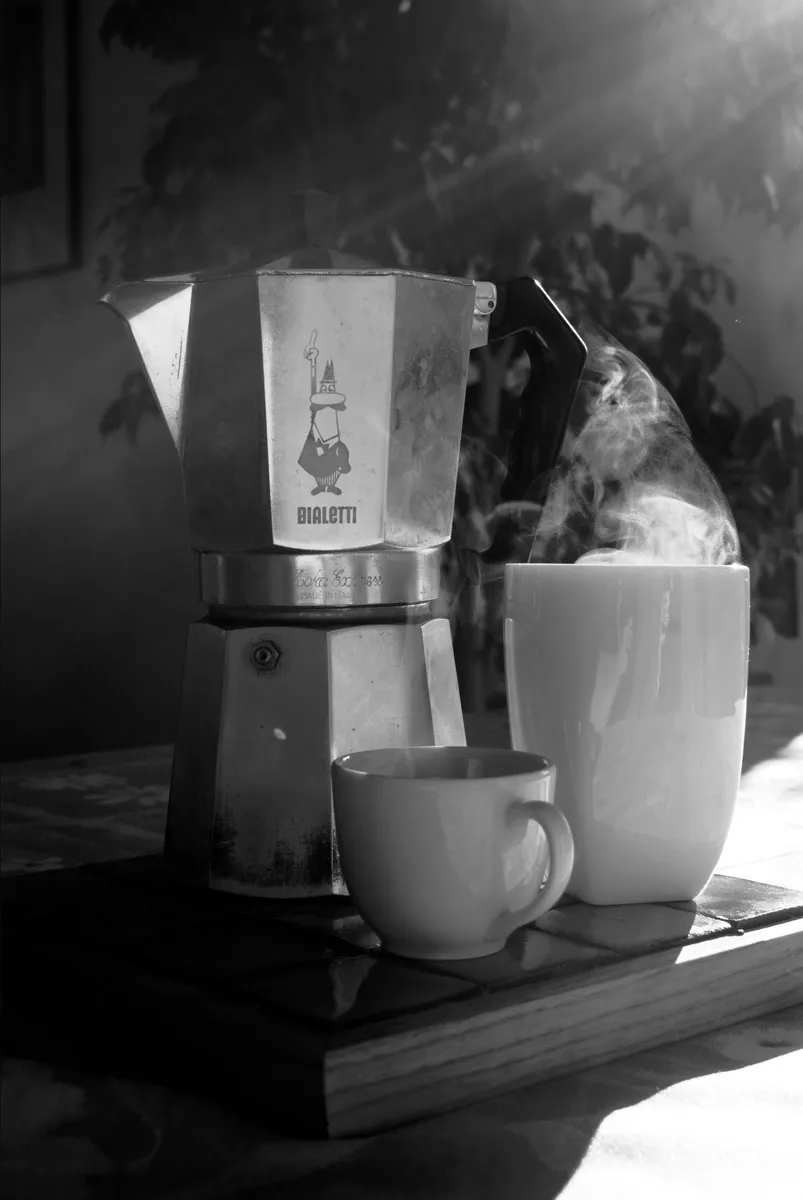 Cup of coffee served alongside a Bialetti Moka Express pot