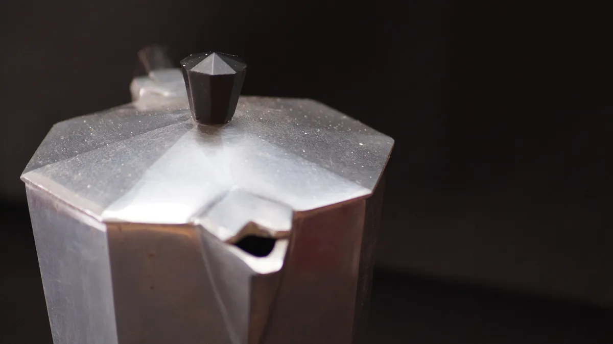 Close-up of a moka pot showing the upper chamber and spout