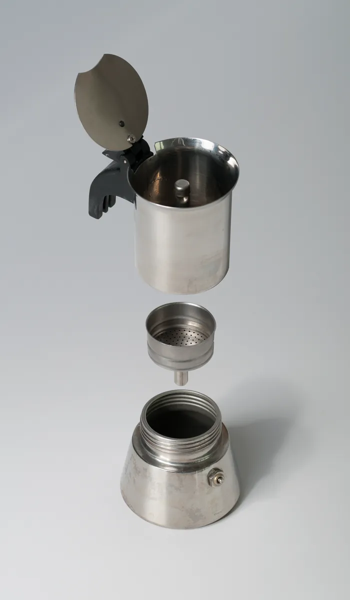 Exploded view of moka pot components including base, funnel basket and upper chamber